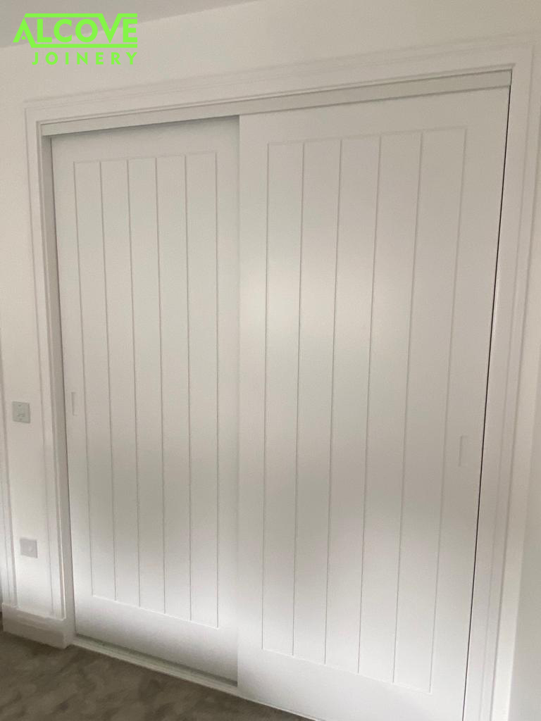 New wardrobe interior layout Oak effect melamine faced furniture panel construction incorporating shelving, hanging and custom-made drawers. New bespoke grooved detail sliding door-set fitted - spray finished in a smooth white finish.