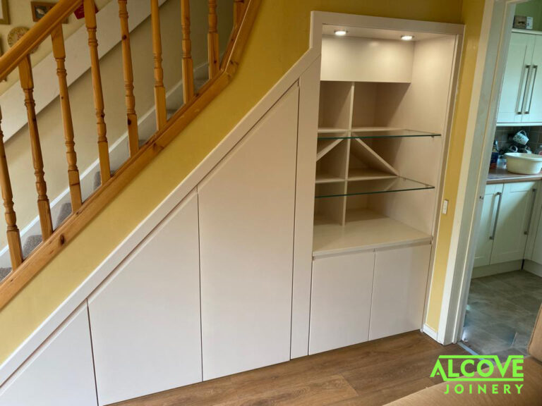 Bespoke understair storage unit Featuring pull out drawer sections, open wine rack and glass shelved section above electric meter housing cabinet. Spray finished exterior components - satin white finish.